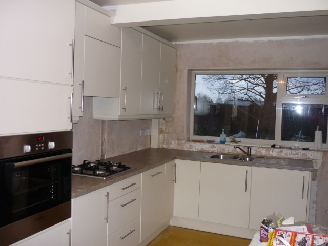 White kitchen fitted around a boxed-in ceiling beam