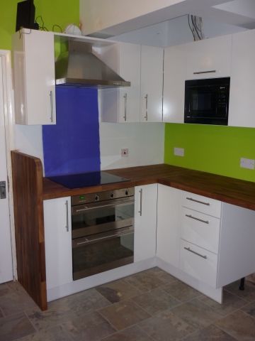 White corner units with a dark wood-effect worktop