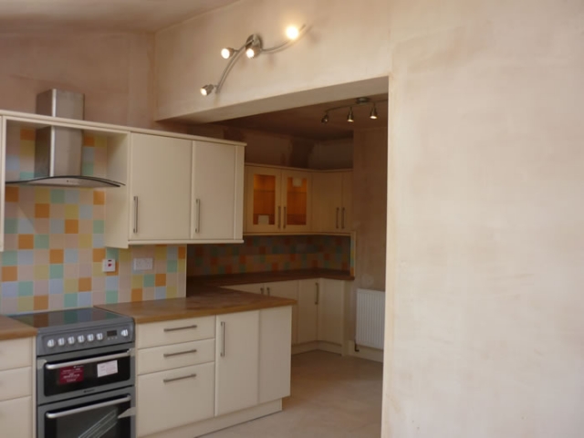 Range cooker and chimney hood in a cream fitted kitchen