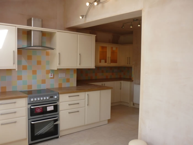 Cream kitchen with oak worktops and a mosaic tiled splashback